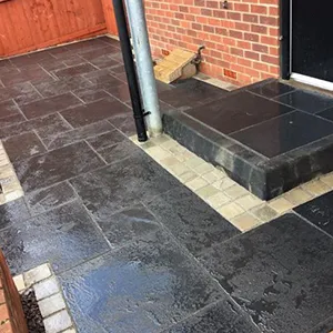 a brick building with a black door and steps
