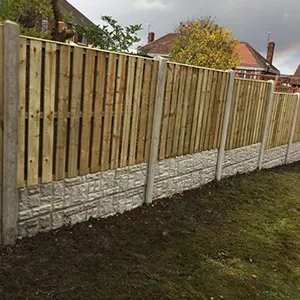A fence made of wood and stone with a rainbow in the background.