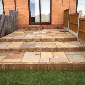 A brick patio with steps leading to a patio.